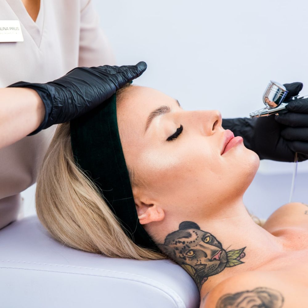 Zabieg na twarz wykonywany przez specjalistkę w rękawiczkach, klientka w opasce relaksacyjnej podczas pielęgnacji skóry